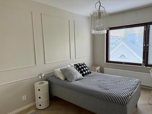 a bedroom with a bed and a window and a chandelier at Beautiful home in the center of Rovaniemi in Rovaniemi