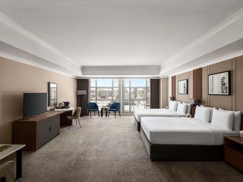 a hotel room with two beds and a television at Anwar Al Madinah Mövenpick in Al Madinah
