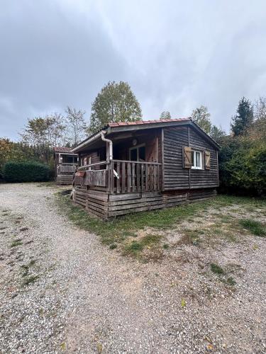 a log cabin with a porch on a gravel road at chalet montana 5_4 pers in Roquefeuil