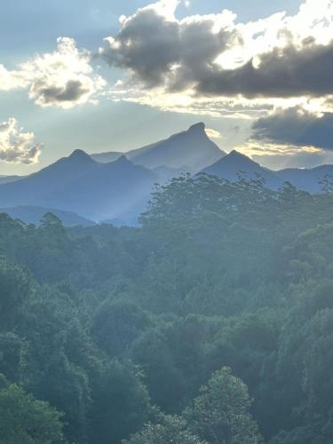a view of a mountain range with clouds and trees at Ecoasis Mami Wata Rainforest Haven in Uki
