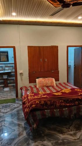 a bedroom with a bed with a wooden headboard at The Heaven Town in Hawālbāgh