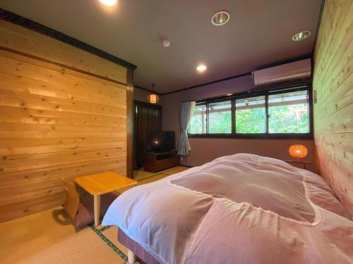 a bedroom with a bed and a television in it at Space haku - Vacation STAY 82838v in Isumi
