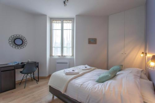 ein weißes Schlafzimmer mit einem Bett, einem Schreibtisch und einem Schreibtisch in der Unterkunft Appartement 2 chambres au coeur de Chambery in Chambéry