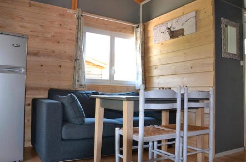 a living room with a couch and a table at Chalet Montana 4 pers in Roquefeuil