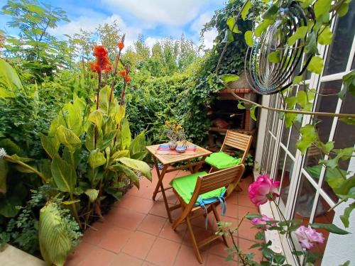 a patio with a table and chairs and plants at Casa Flow and Glow in Santiago do Cacém
