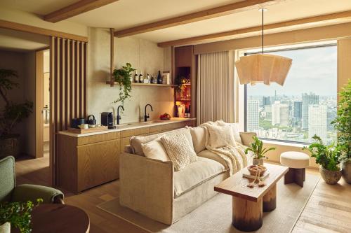 a living room with a couch and a large window at 1 Hotel Tokyo in Tokyo
