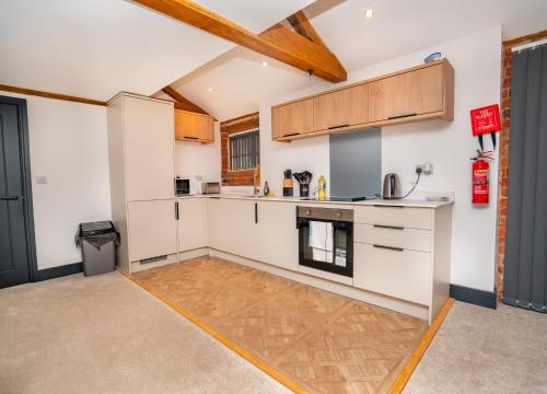 a kitchen with white counters and wooden cabinets at Spacious 2 Bedroom Apartment in Central Newark in Newark upon Trent