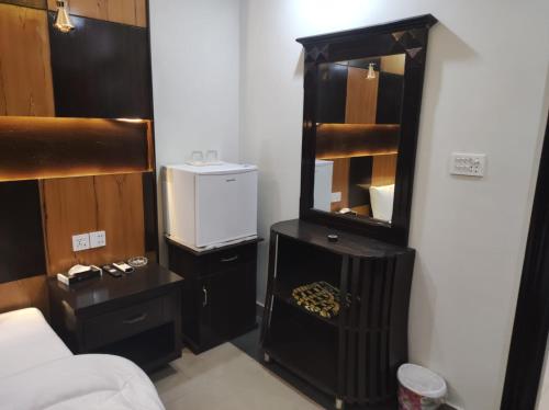 a small room with a bed and a mirror at Osma Living Apartment Peshawar in Peshawar