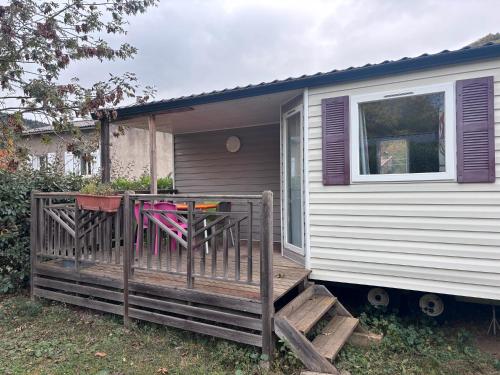 a porch of a tiny house with a deck at Mobil-home 6 personnes in Roquefeuil