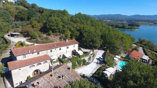eine Luftaufnahme eines Hauses auf einem Hügel neben einem See in der Unterkunft La Fratta in Barberino di Mugello