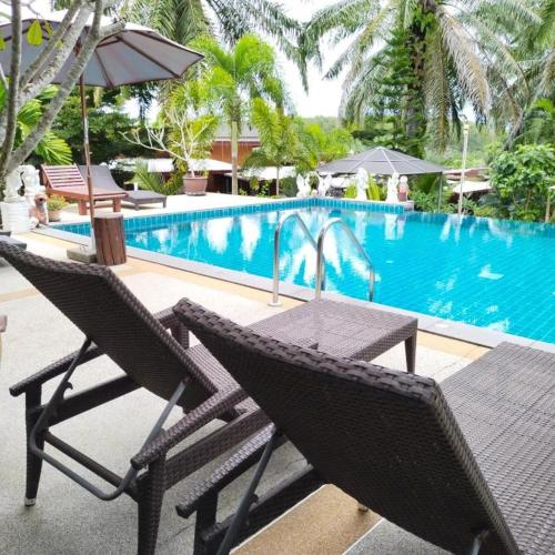 a table and chairs next to a swimming pool at Palmthien Pool Villa Aonang in Ao Nang Beach