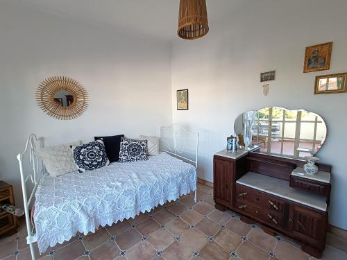 a bedroom with a bed and a mirror and a dresser at Casa Flow and Glow in Santiago do Cacém