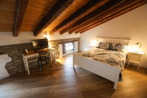 a bedroom with a bed and a desk with a television at Casa Nora Apartments in Gorizia