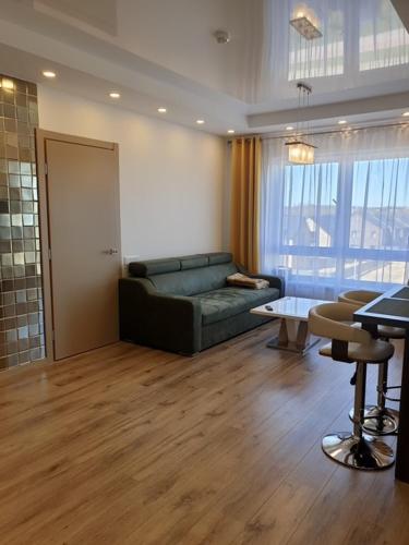 a living room with a couch and a table at Cozy One-Bedroom Retreat in Klaipėda I Cohost in Melnragė