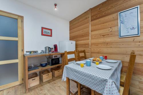 a dining room with a table and a kitchen at Près des Forts in Briançon