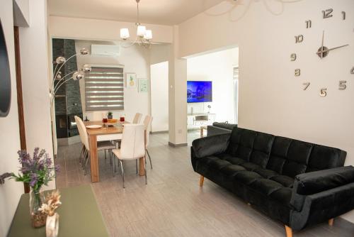 a living room with a black couch and a table at Bluewave Apartment in Pyla