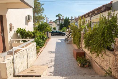 an alley with a car parked on a street at Bluewave Apartment in Pyla