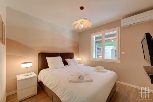 1 Schlafzimmer mit einem Bett, einem Fenster und einem TV in der Unterkunft La Familial - 6V - Parking - Jardin - Bureau in Montbazon