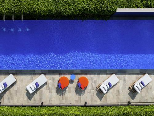 an overhead view of a swimming pool with chairs and a pool at ibis Styles Bangkok Silom in Bangkok