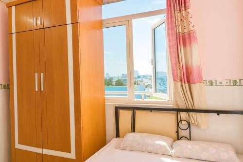 ホーチミン・シティにあるNgọc Mơ Motelのベッドと窓のある小さな寝室