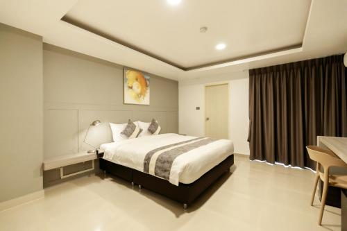 a bedroom with a bed and a table and a desk at UTD8 Hotel and Residence in Bangkok