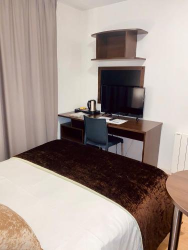 ein Hotelzimmer mit Bett und Schreibtisch mit Computer in der Unterkunft Central Fac in Bourg-en-Bresse