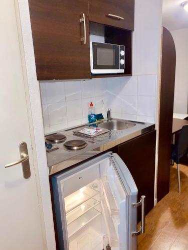 eine kleine Küche mit Spüle und Mikrowelle in der Unterkunft Central Fac in Bourg-en-Bresse