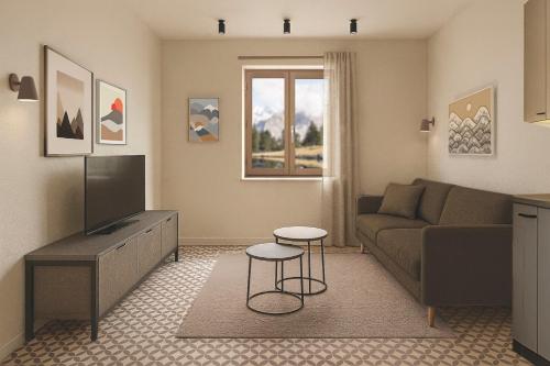 a living room with a couch and a television at Central Guest in Sauze dʼOulx