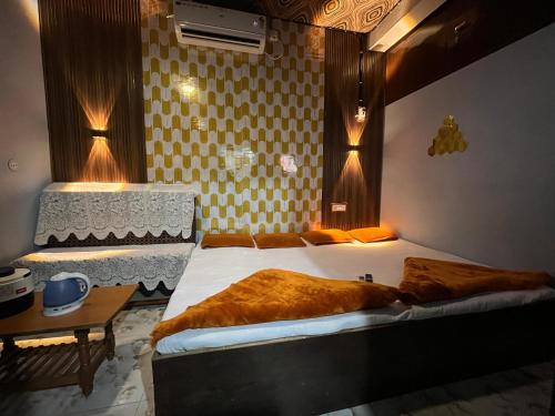 a bedroom with a bed and a table and lights at Mangal kripa homestay in Ujjain