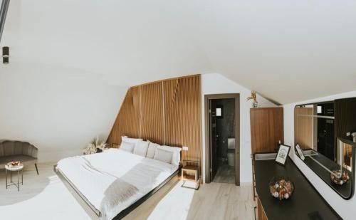 een slaapkamer met een groot wit bed en een tv bij Azimuth in Buhalniţa