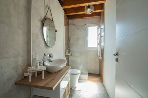 a bathroom with a sink and a toilet and a mirror at Apartamento en casco histórico Exclusivo con AC in San Martín de Valdeiglesias
