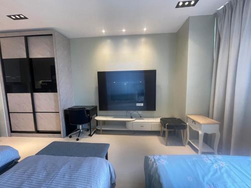een slaapkamer met 2 bedden en een groot televisiescherm bij Nice and Cosy RDA13A07B for 4 guests in Kuching