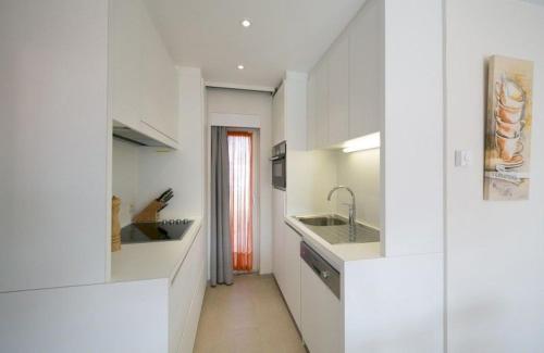 a white kitchen with white counters and a sink at Holiday Home Jonckershof in Middelkerke