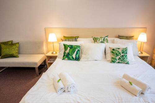 a bedroom with a large white bed with towels on it at Hotel Junior Poděbrady in Poděbrady