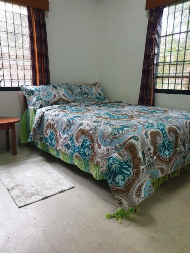 a bed with a colorful comforter in a bedroom at Jetpoint Bed & Breakfast in Nadi