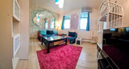 a living room with a table and a pink rug at Artsy fully equipped 2 bedrooms House all to yourself! in Bucharest