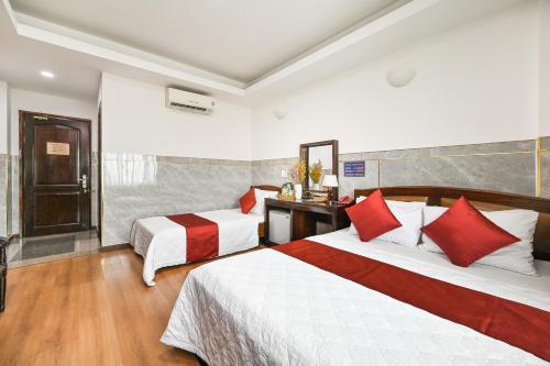 ホーチミン・シティにあるDuc Minh Saigon Airport Hotelの赤い枕が付いたベッドが2つあるホテルの部屋