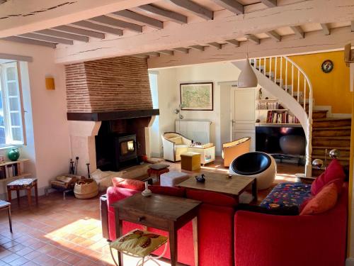 a living room with a red couch and a fireplace at Cottage authentique et chaleureux entre Pau et Lourdes pour 7 personnes in Nousty