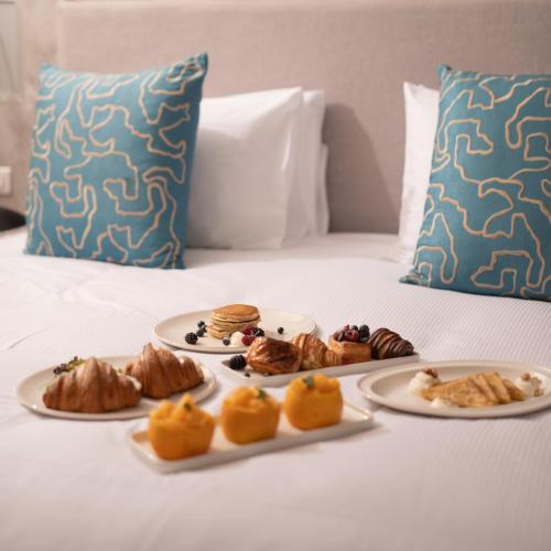 a table with plates of food on a bed at Pickalbatros SUNGO Club - All Inclusive in Marrakech