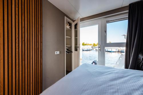 にあるFloating holiday home close to AMSのベッドがあり水辺の景色が見える寝室