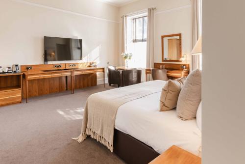 Una habitación de hotel con una cama grande y un televisor. en The Bank, en Anstruther