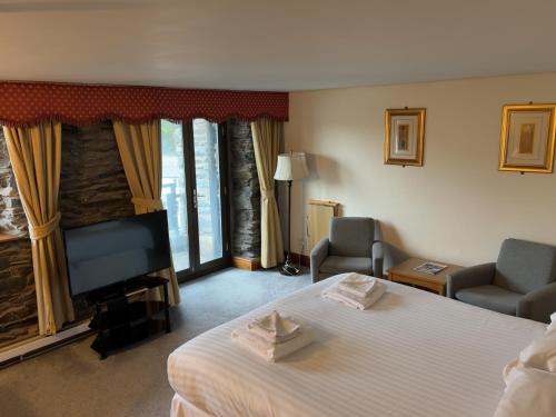 a hotel room with a bed and a flat screen tv at Whitewater Hotel & Spa in Newby Bridge