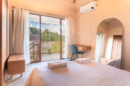 ein Schlafzimmer mit einem Bett und einem großen Fenster in der Unterkunft Villa Armonia Siargao in General Luna