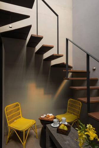 two chairs and a table in a room with a staircase at Dos Casas Hotel & Spa in San Miguel de Allende