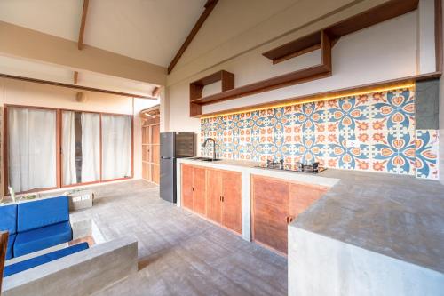 eine große Küche mit einer Theke und einem blauen Stuhl in der Unterkunft Villa Armonia Siargao in General Luna