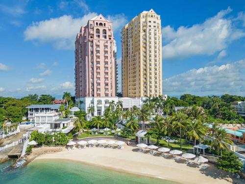 a view of a beach with two tall buildings at Mövenpick Hotel Mactan Island Cebu in Mactan