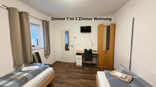 a room with two beds and a desk in it at Kim Homestay B Zimmer B1 in Sömmerda