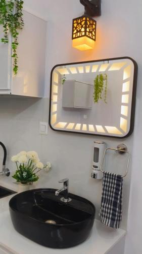 a bathroom with a black sink and a mirror at CLIFF HEAVEN Apartment in Varkala