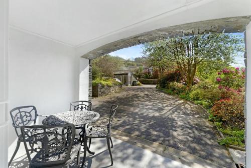 a patio with a table and chairs and a walkway at Fisherbeck Nest in Ambleside