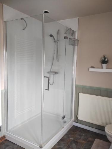 a shower with a glass door in a bathroom at Peaceful 1 Bed Self-Contained Property with Parking in Wivenhoe